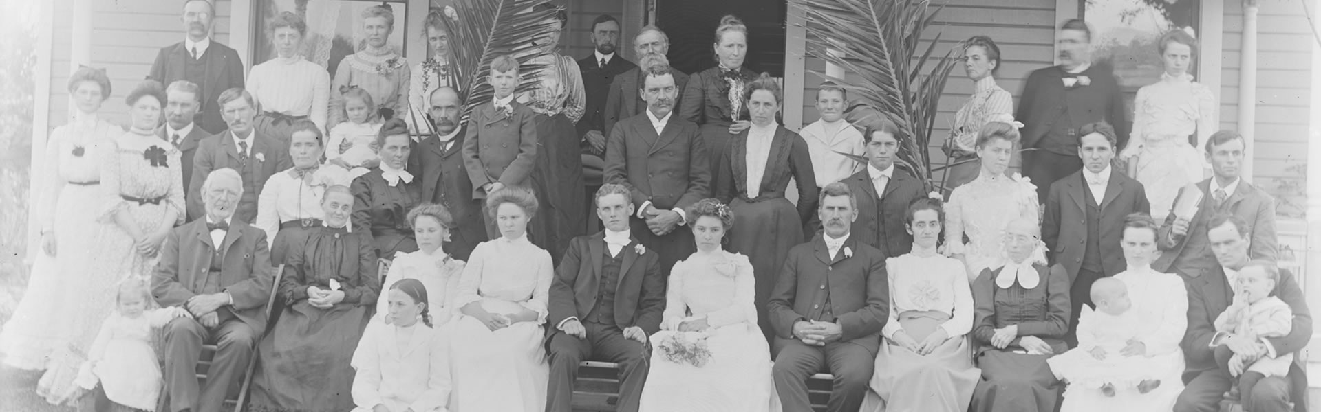 Turn-of-the-century wedding party seated on front porch of a Whittier home.